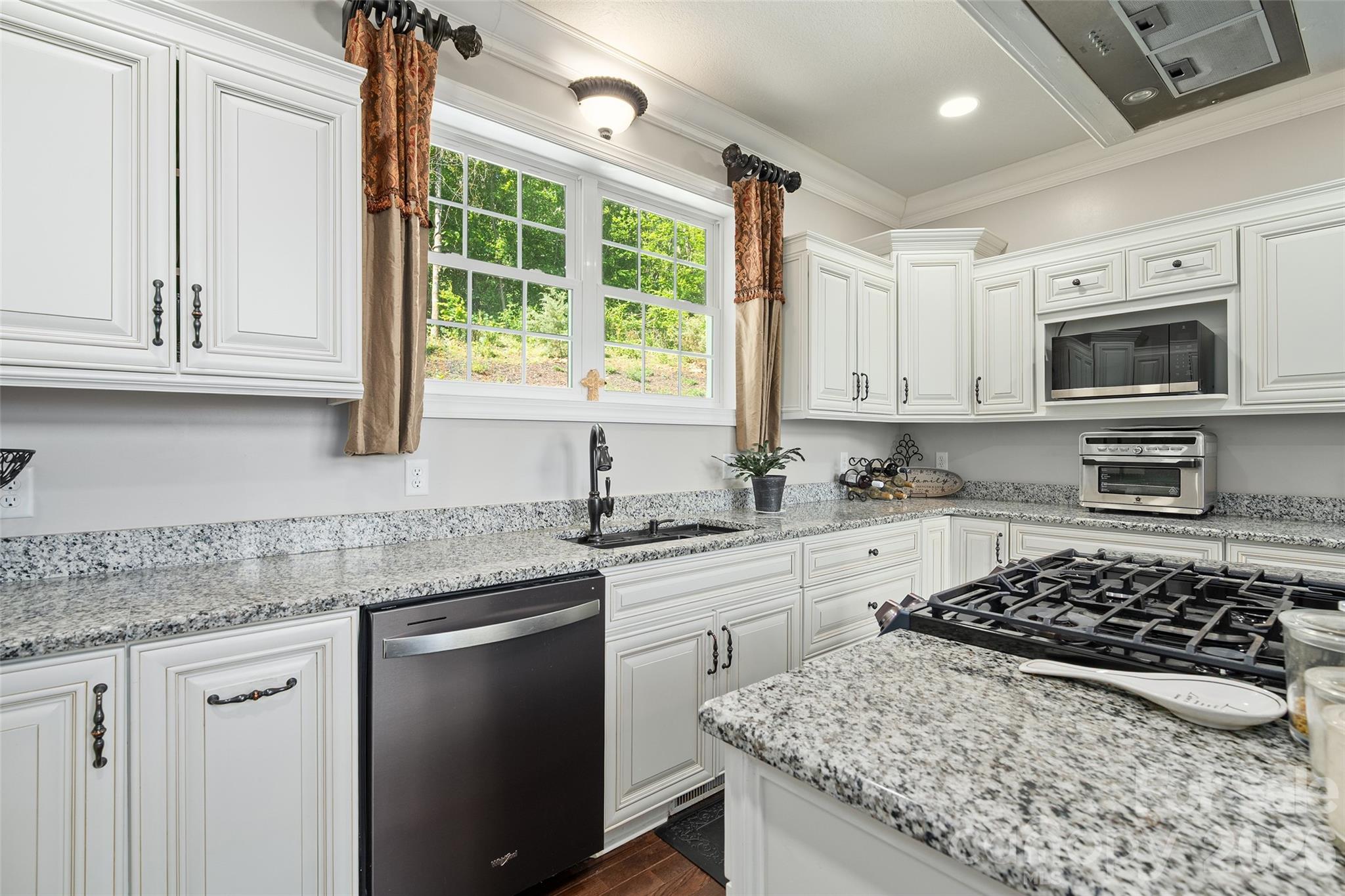 114 Nesting Ridge Waynesville, NC 28785 - Photo 10 of 40 a kitchen with stainless steel appliances granite countertop a stove a sink dishwasher and a microwave oven with white cabinets