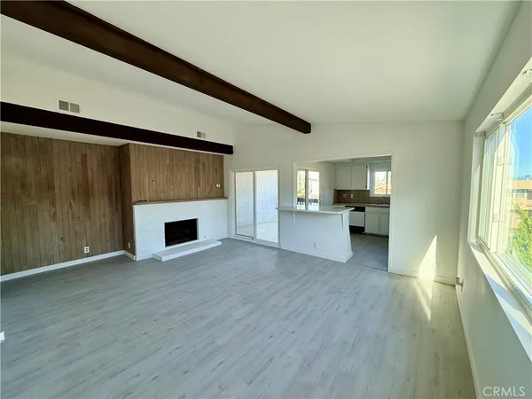 a view of empty room with wooden floor and fireplace