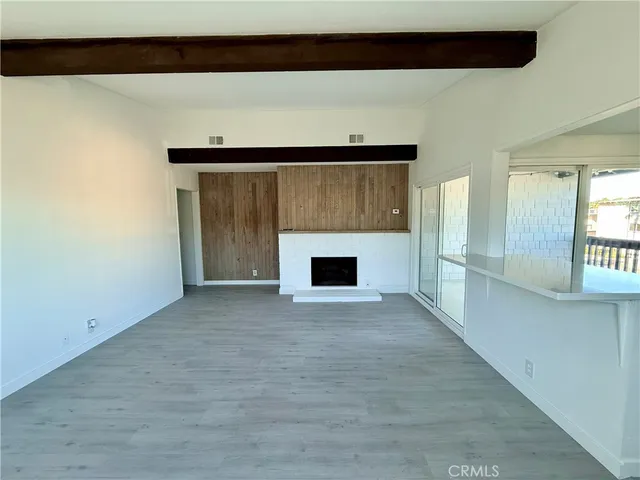 a view of an empty room with a fireplace and a window