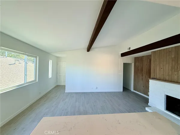 an empty room with wooden floor and fireplace