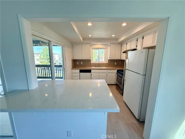 a large kitchen with a large window and refrigerator