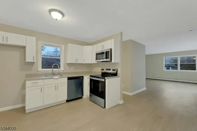a view of a kitchen with a sink and a refrigerator