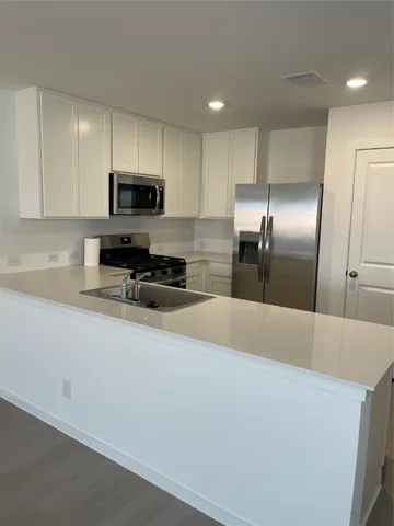a kitchen with stainless steel appliances a refrigerator sink microwave and cabinets