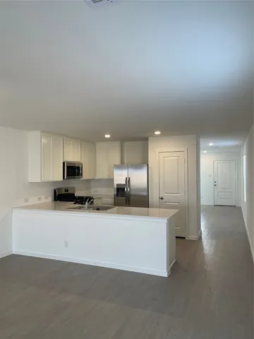 a large white kitchen with kitchen island a sink a stove and a refrigerator