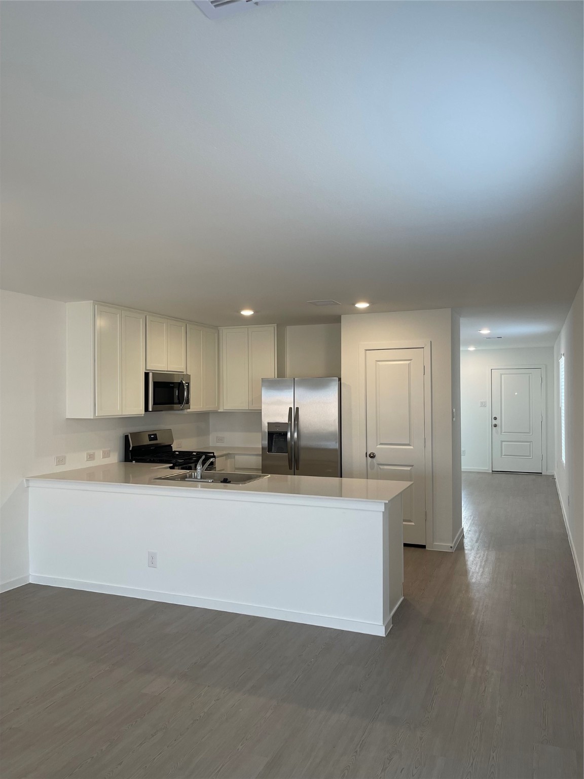 12922 Shells Lane Crosby, TX 77532 - Photo 3 of 14 a large white kitchen with kitchen island a sink a stove and a refrigerator