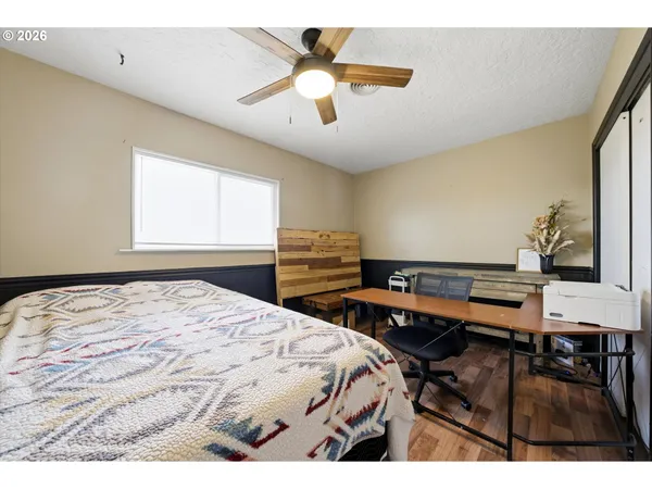 a bedroom with a bed and wooden floor