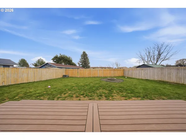 a view of backyard with wooden fence