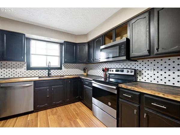 a kitchen with granite countertop wooden cabinets and a stove top oven