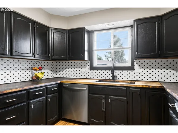 a kitchen with granite countertop a sink stainless steel appliances and cabinets