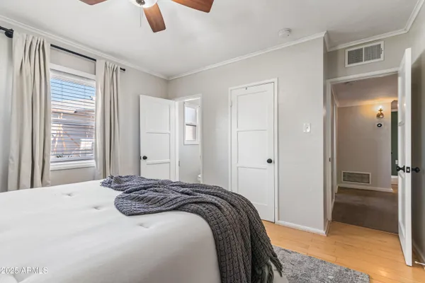 a bedroom with a bed and painting on the wall