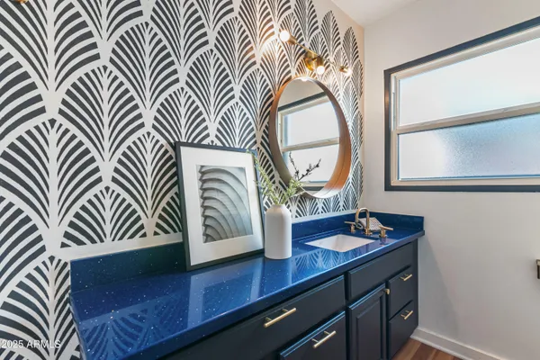 a bathroom with a sink a mirror and next to a window