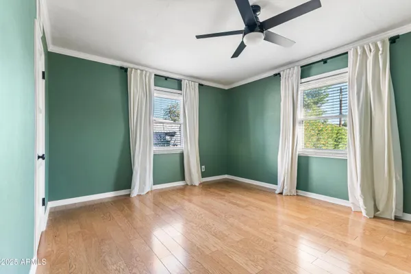 a view of empty room with window and ceiling fan