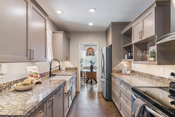 a kitchen with granite countertop stainless steel appliances stove a sink and dishwasher a oven with wooden cabinets