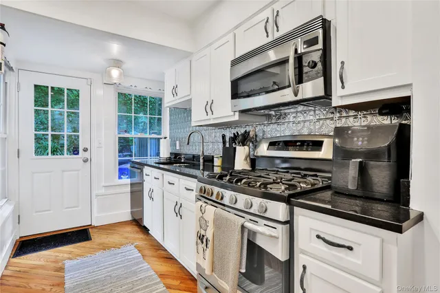 a kitchen with stainless steel appliances granite countertop a stove and a microwave