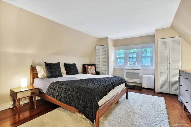 a spacious bedroom with a bed and wooden floor