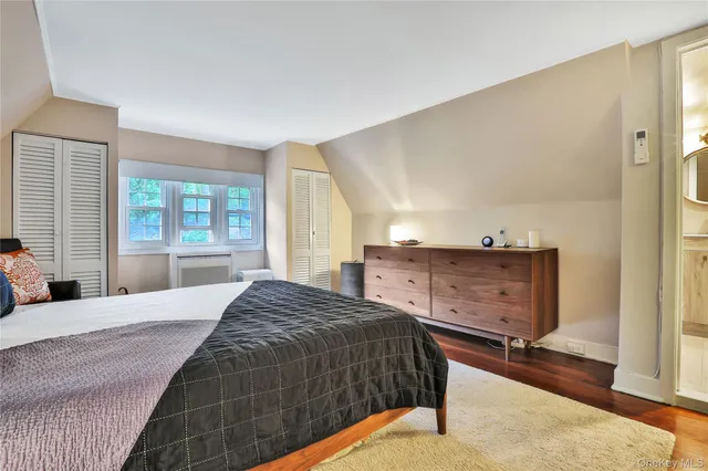 a bedroom with a large bed and windows