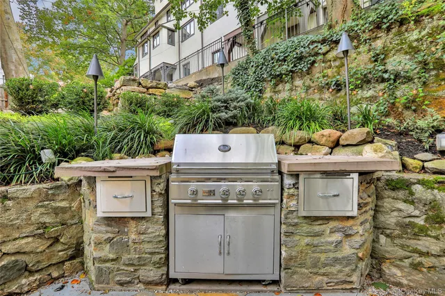 a view of a patio with table and chairs potted plants with wooden floor and fence