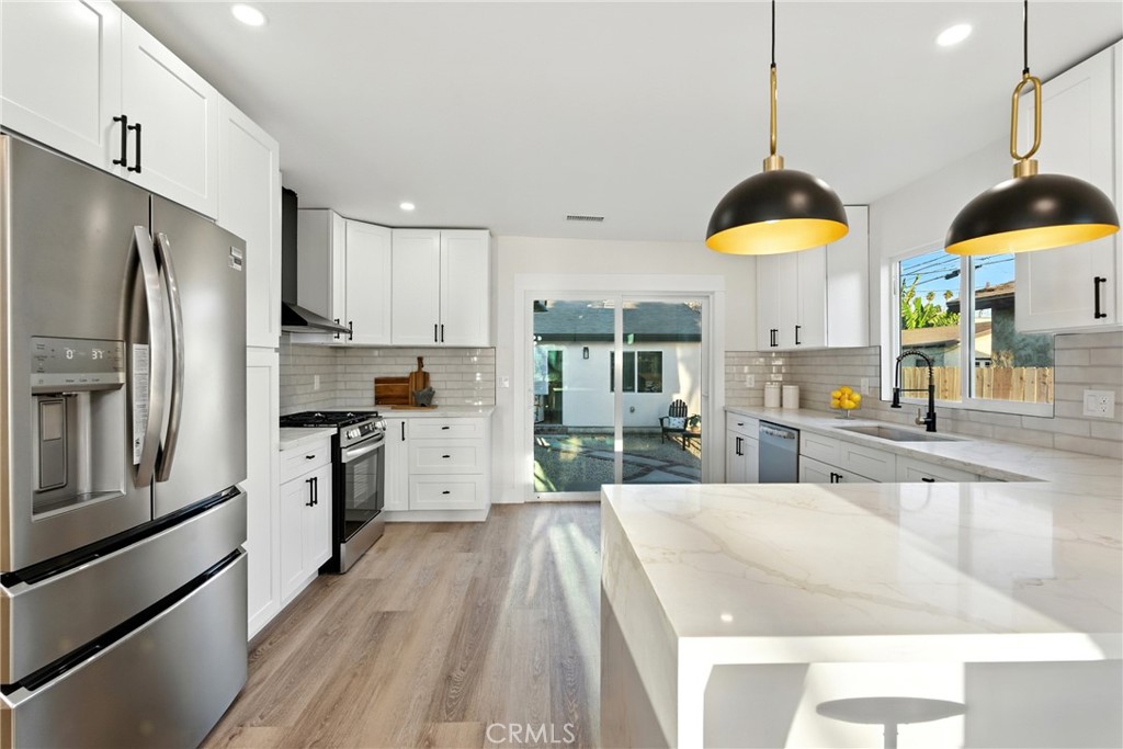 4340 2nd Avenue Los Angeles, CA 90008 - Photo 8 of 51 a kitchen with stainless steel appliances granite countertop a sink a stove and a refrigerator