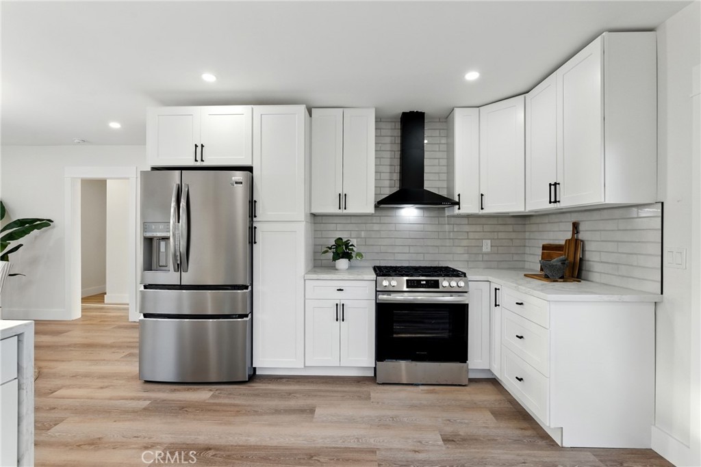 4340 2nd Avenue Los Angeles, CA 90008 - Photo 10 of 51 a kitchen with a refrigerator stove and white cabinets