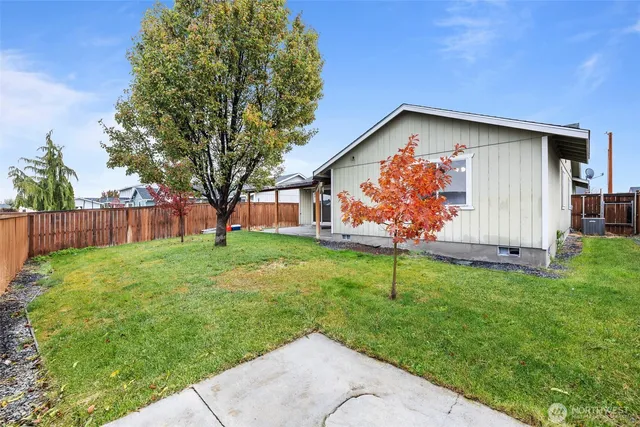 a backyard of a house with plants and wooden fence