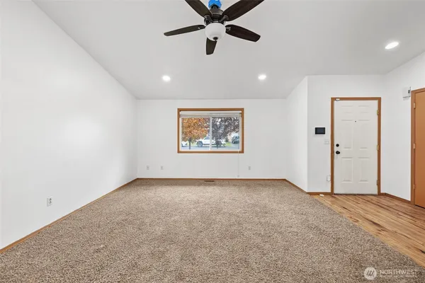 an empty room with fan and windows