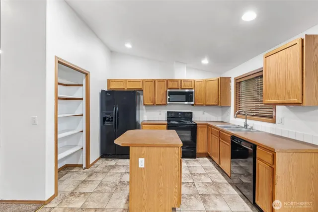 a kitchen with stainless steel appliances a stove refrigerator sink and cabinets