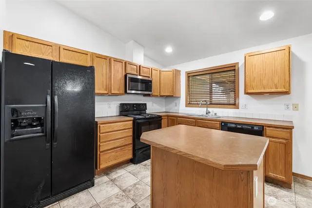 a kitchen with granite countertop a refrigerator and a sink