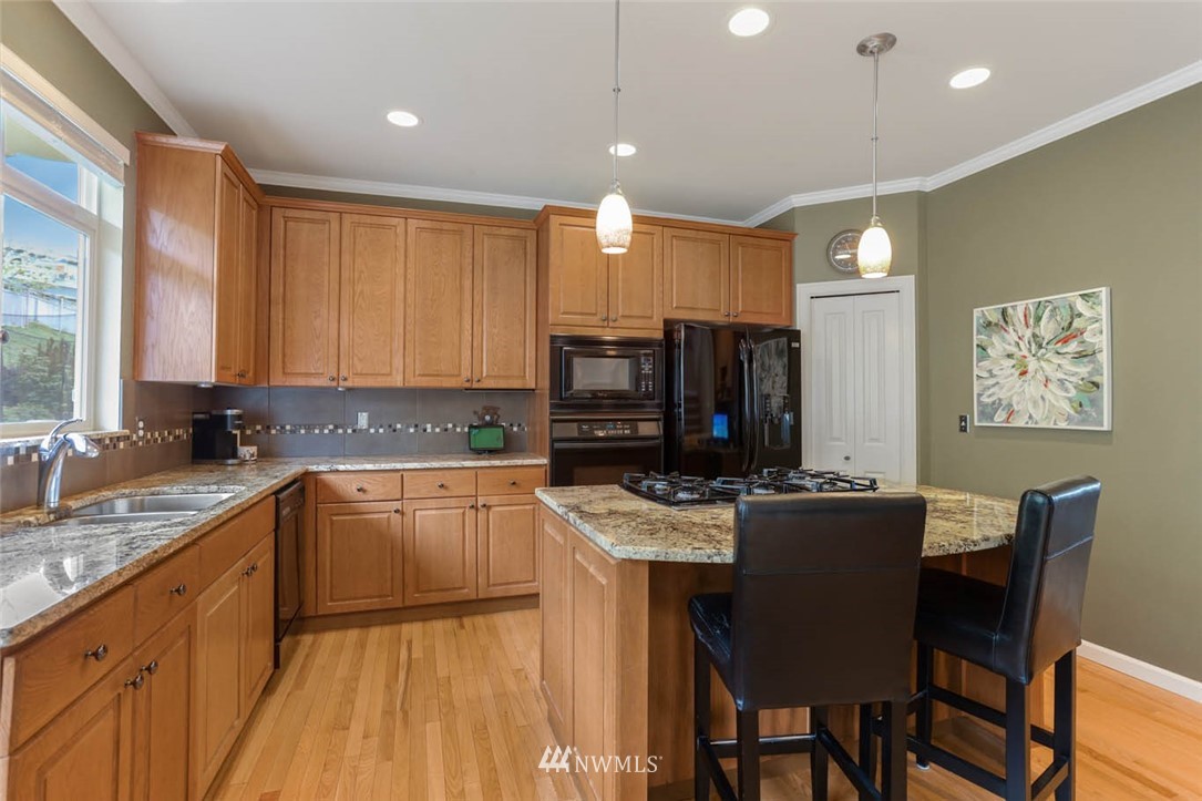 17112 164th Way Southeast Renton, WA 98058 - Photo 13 of 35 a kitchen with kitchen island granite countertop a sink counter top space appliances and cabinets