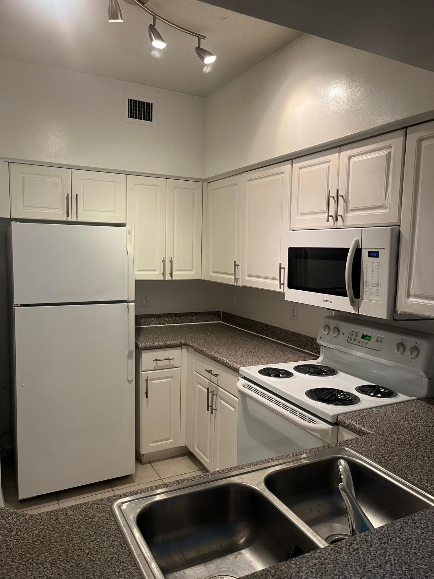 1951 Brandywine Road, Unit 57304 West Palm Beach, FL 33409 - Photo 1 of 2 a kitchen with stainless steel appliances a refrigerator stove and microwave