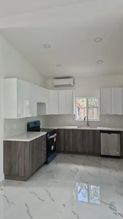 a kitchen with granite countertop a sink a stove and cabinets