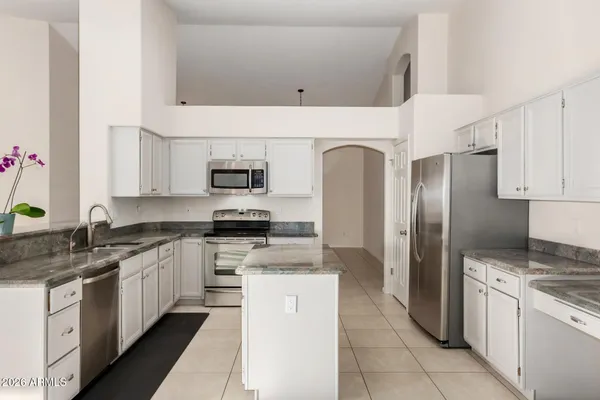 a kitchen with stainless steel appliances granite countertop a refrigerator and a stove