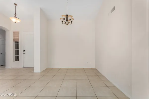 a view of an empty room and chandelier fan