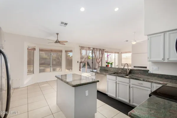 a kitchen with granite countertop a sink and white cabinets