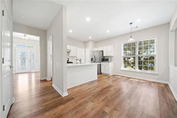 a view of a kitchen with wooden floor and a window