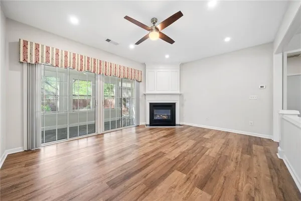 an empty room with wooden floor and a fireplace