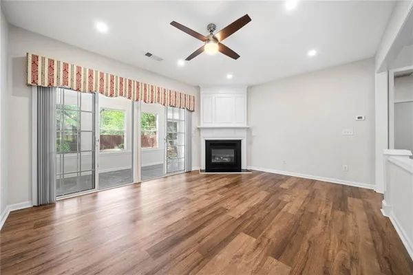 a view of an empty room with a fireplace and a window