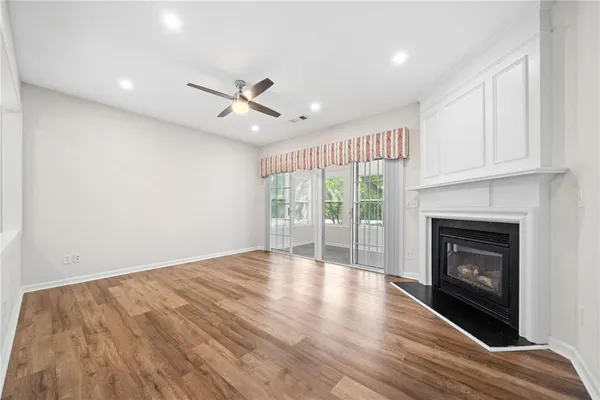 a view of an empty room with a fireplace and a window