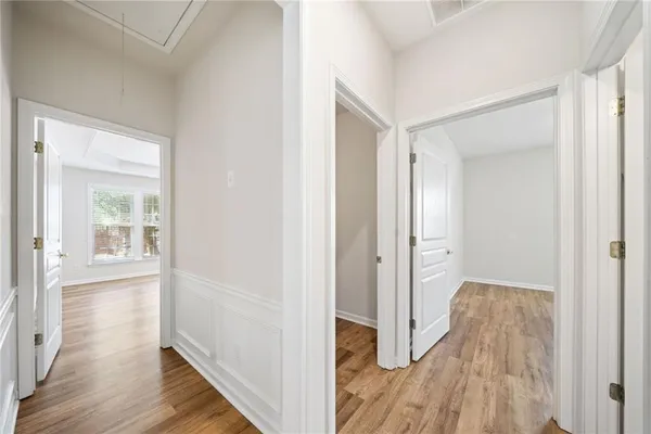 a view of hallway with bathroom and wooden floor