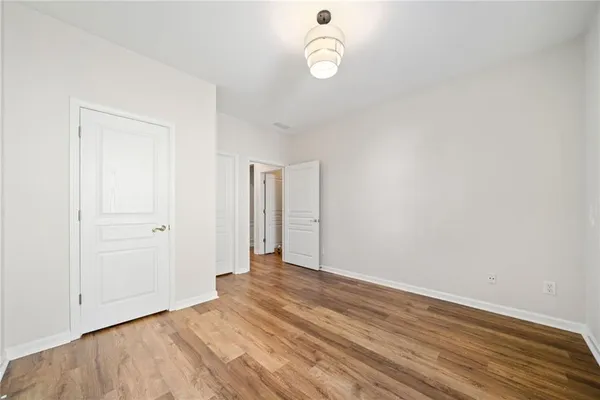 a view of a room with wooden floor and white walls