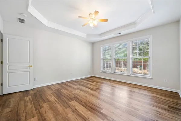 a view of an empty room with a window and wooden floor
