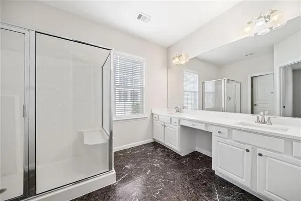 a bathroom with a double vanity sink a mirror and a shower