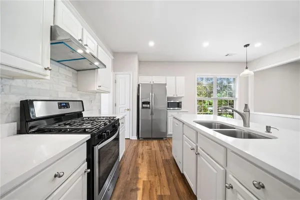 a kitchen with stainless steel appliances granite countertop a sink stove and refrigerator