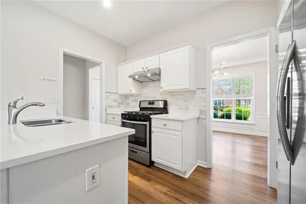 a kitchen with a stove a sink and a refrigerator