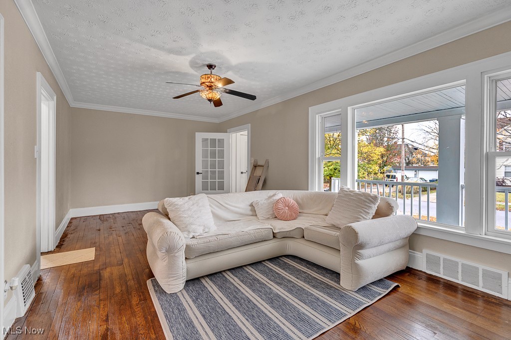 2127 Rossmoor Road Cleveland Heights, OH 44118 - Photo 6 of 21 Living area featuring visible vents, hardwood / wood-style flooring, ornamental molding, and a ceiling fan