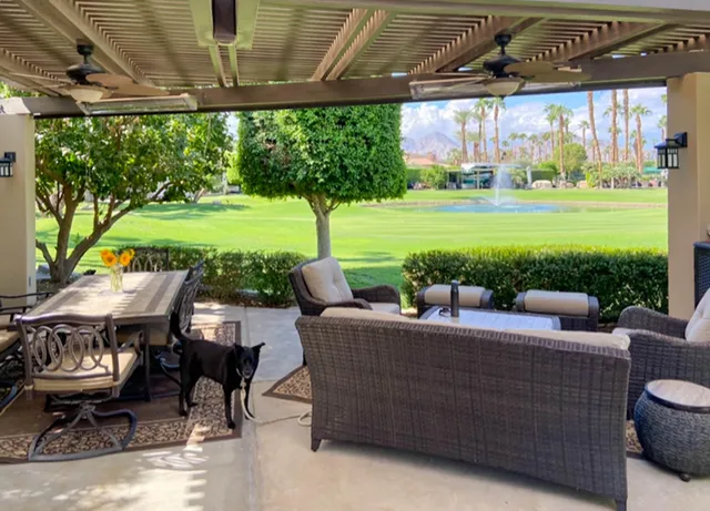 a view of a patio with table and chairs potted plants with floor to ceiling windows