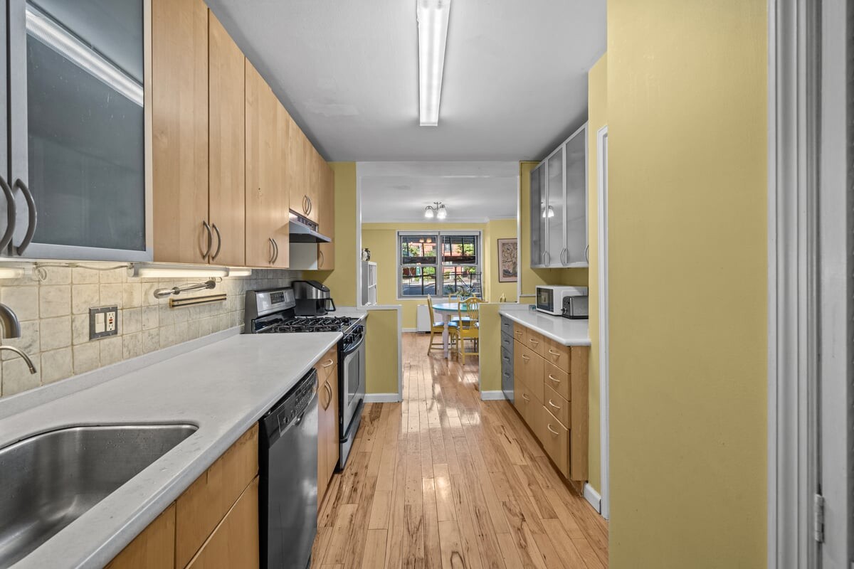 2500 Johnson Avenue, Unit 2NP Bronx, NY 10463 - Photo 12 of 45 a kitchen with kitchen island a counter top space a sink a stove and a refrigerator