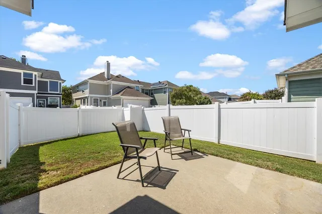 a view of a patio with table and chairs with wooden floor and fence