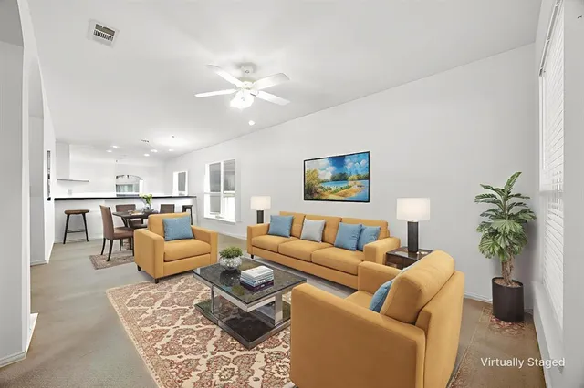 a living room with furniture kitchen view and a potted plant