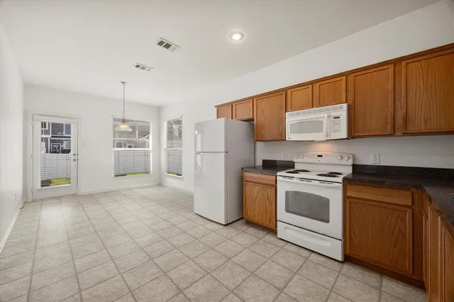 a kitchen with a refrigerator sink and cabinets