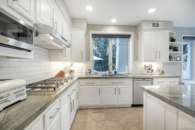 a kitchen with stainless steel appliances granite countertop a sink and cabinets